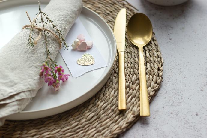 a white plate topped with a gold fork and knife